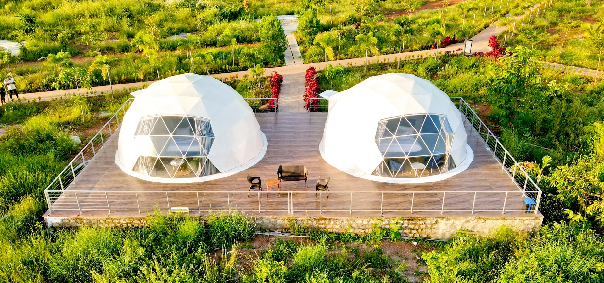 Aerial view of two domes on a shared deck among the greenery