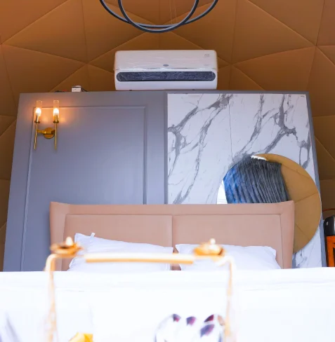 Bed and gold sconces inside a dome